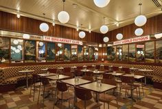 an empty restaurant with tables and chairs in the center, surrounded by large round lights