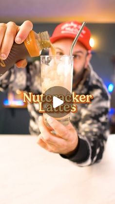 a man is holding a drink with a straw in his hand and the word nut cracker laves on it