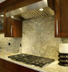 a stove top oven sitting inside of a kitchen next to wooden cabinets and counter tops