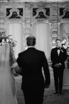 a bride and groom standing at the alter