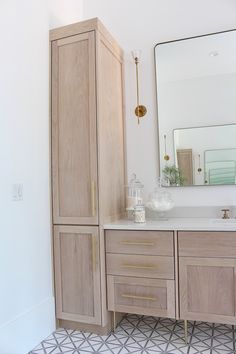 a bathroom with a large mirror and wooden cabinets