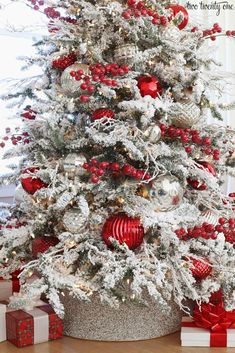 a white christmas tree with red and silver ornaments