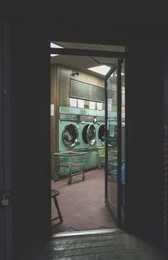 an open door leading to a washer and dryer in a laundroom