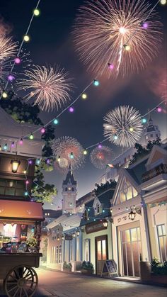 fireworks in the sky over a street with buildings and lights hanging from it's sides