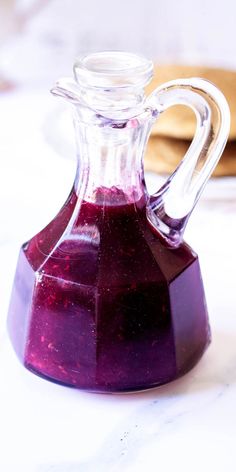 a purple liquid in a glass jug on a table