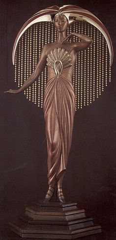 a statue of a woman in a gold dress with her hands on her hips, holding a fan