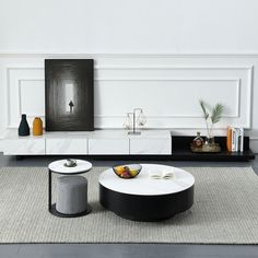 a modern living room with white walls and black furniture on the floor, including a coffee table