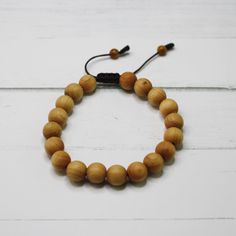 Who doesn't love a natural wood bracelet? Sandalwood is a sacred wood with a lovely aromatic scent.  Excellent as a planned gift for a friend, loved one, or yourself.  Perfect for everyday wear! If you don't like it, you don't have to keep it. If you are not 100% satisfied, your purchase can be returned or exchanged. See details FAQs. ----DESCRIPTION---- This natural, aromatic sandalwood mala bracelet is made with 8 mm Sandalwood and 4 mm Tiger's Eye pull ends. Using a 1 mm brown nylon cord. With an adjustable slide cobra knot. The Sliding knot closure makes the mala flexible approx 1.5 inches to allow going over the hand. ---- DETAILS & DIMENSIONS---- Sandalwood Bracelet, Meditation Gifts, Adjustable Bracelet, Calming Aromatic Natural Wood Bracelet, Unisex Bead Bracelet, Wooden Bracelet G Cobra Knot, Sandalwood Bracelet, Sandalwood Mala, Sliding Knot Closure, Wooden Bracelet, Meditation Gifts, Wood Bracelet, Mala Bracelet, Sliding Knot