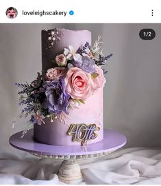 a pink and purple cake with flowers on top