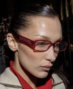 a woman wearing red glasses with the word chanel on it's forehead and her hair pulled back