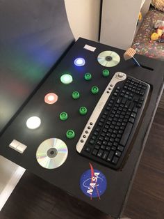 a computer keyboard sitting on top of a desk with cd's and discs around it