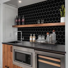 the kitchen counter is clean and ready to be used for cooking or baking, with black hexagonal tiles on the backsplash