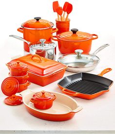 an assortment of orange pots and pans