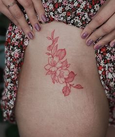 a woman's stomach with a flower tattoo on her belly and the bottom part of her body