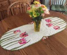 a vase filled with flowers sitting on top of a wooden table