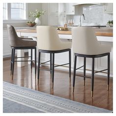 two white chairs sitting in front of a kitchen counter