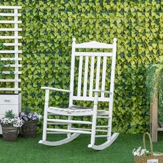 a white rocking chair sitting in front of a green wall