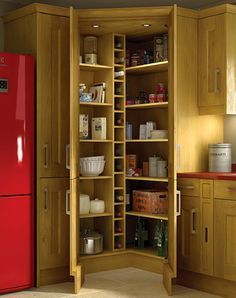 a red refrigerator freezer sitting inside of a wooden cabinet