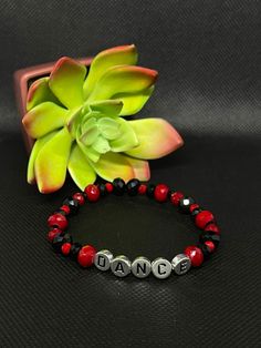 Black & Red Dance Stretchy Bracelet About the product  Colors: Black & red  Materials: Glass & Acrylic  * This one of a kind bracelet would be perfect to bring a smile to your friends and family. It is lightweight and fashionable, as well as stretchy. It's the perfect gift for family members or friends that love dance! * Contact and Follow Us!  If you have any questions about this bracelet feel free to message us on Etsy. We will be happy to answer them.  Shop our store:  https://www.etsy.com/shop/Toparadiseandbeyond Facebook: https://m.facebook.com/To-Paradise-And-Beyond-194702878032699/ Instagram: https://www.instagram.com/toparadiseandbeyondco/ Trendy Red Bracelets For Party, Casual Black Beaded Bracelets For Valentine's Day, Adjustable Red Stretch Bracelet For Valentine's Day, Customized Adjustable Red Wristband, Black Bracelets With Letter Beads For Party, Black Letter Beads Bracelets For Parties, Black Letter Beads Bracelet For Party, Black Party Bracelet With Letter Beads, Black Bracelets For Party On Valentine's Day