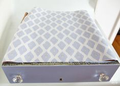 an open box sitting on top of a white counter next to a wooden floor and door