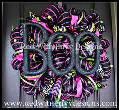 a purple and black door wreath with the word boo on it's front entrance