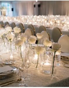 the tables are set with white flowers and candles