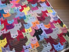 a crocheted blanket with many cats on it