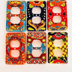 four decorative switch plates are shown in different colors