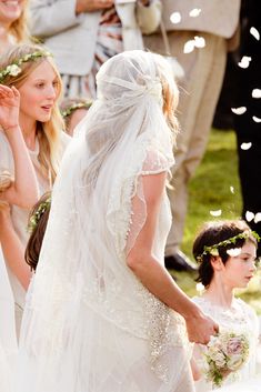 a bride and groom walking down the aisle with confetti falling all around them