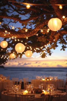 the tables are set with paper lanterns and place settings