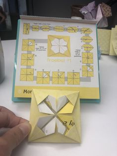 a person is making a paper origami model