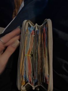 a person is holding a wallet full of papers