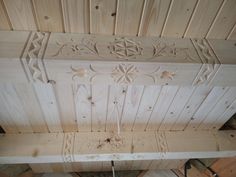 the ceiling is made out of wood and has carvings on it