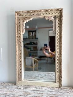 a person taking a photo of a mirror with their cell phone in front of it