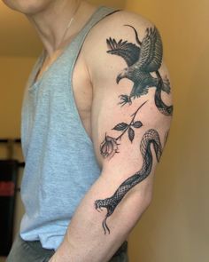 a man with a bird and snake tattoo on his arm