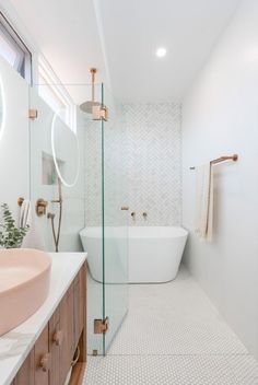 a bathroom with a bathtub, sink and mirror in it's center area