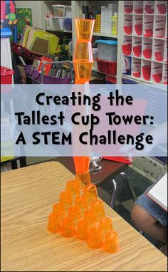 an orange vase sitting on top of a wooden table next to a pile of plastic cups