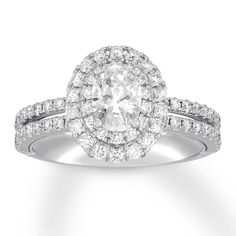 an oval shaped diamond engagement ring with pave set diamonds on the band and shoulders