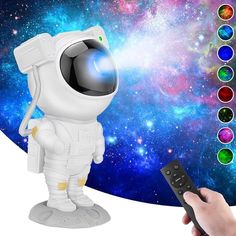 an astronaut is holding a remote control in front of a colorful background with stars and planets