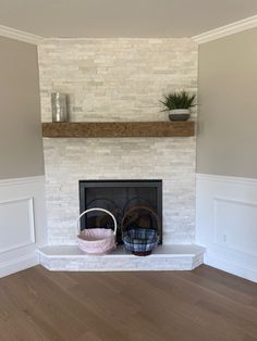 a living room with a fireplace, basket and potted plant on the mantel