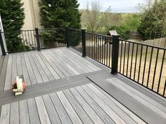 a skateboard laying on the ground in front of a wooden deck with black railings