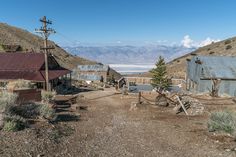 an old building in the middle of nowhere with mountains in the backgrouds