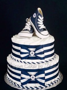 a blue and white striped cake with converse shoes on top, tied to the bottom