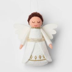 a white angel ornament hanging from a string with gold trimmings on it