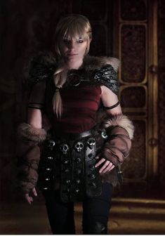 a woman dressed in armor and holding her hands on her hips