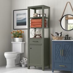 a white toilet sitting next to a blue cabinet