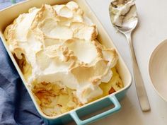 a casserole dish with whipped cream in it next to a plate and spoon