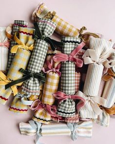 a pile of wrapped presents sitting on top of a pink table next to each other