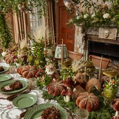 the table is set with green plates and pumpkins