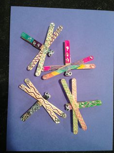 five different colored paper clips are arranged in a circle on a purple sheet with black background